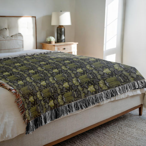 Luxurious woven cotton throw blanket featuring symmetrical scarab beetle pattern in olive green on black background with white fringe trim. Perfect for dark academia, gothic, or cottagecore decor as wall hanging or cozy throw. Mystical home gift.